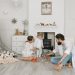Warm family scene of parents playing with their daughter in a cozy white room.